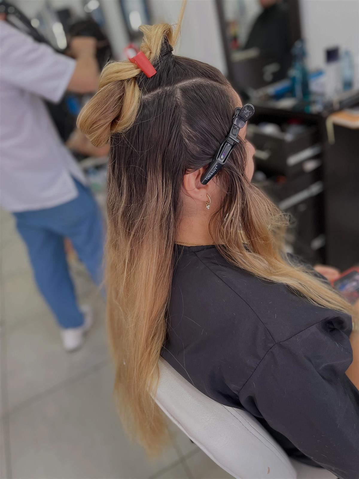 Proceso de color en el salón, con el cabello separado por secciones