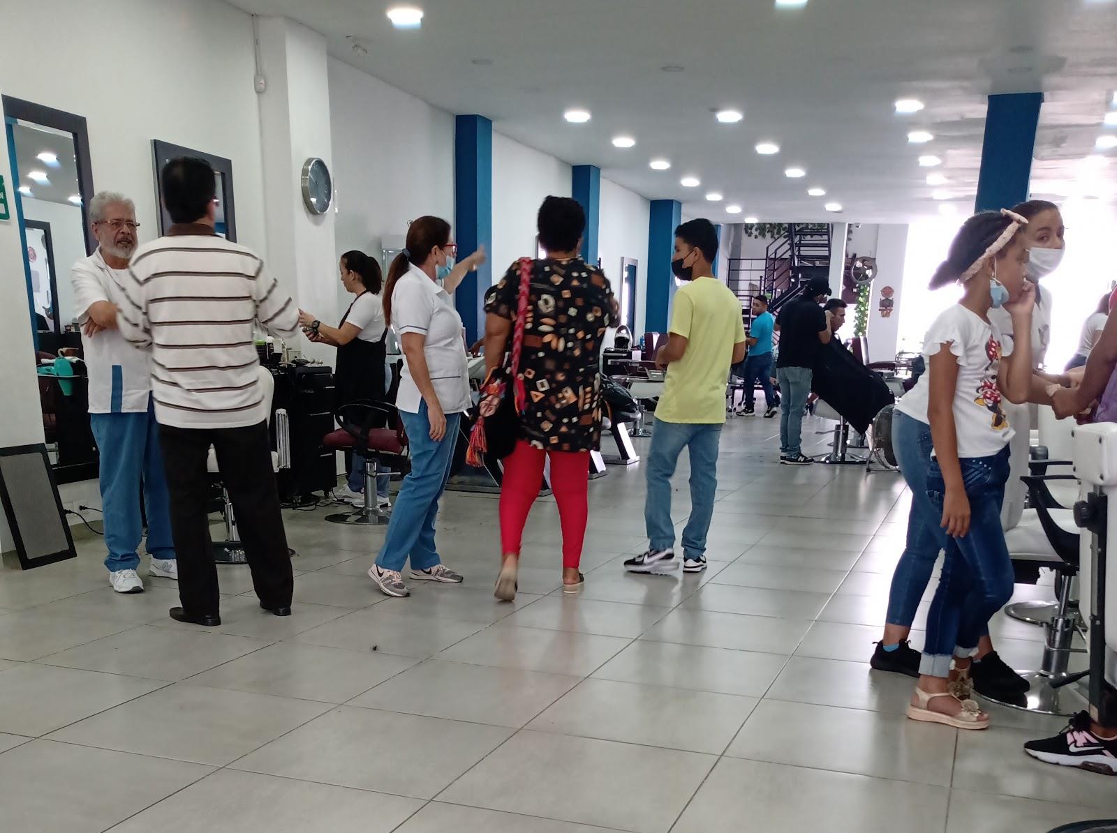 El salón de Stylos por dentro: puestos de trabajo, columnas azules y la escalera al fondo